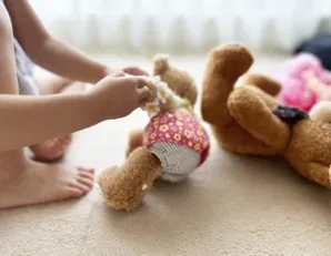 カウンセリング　夜尿症　万引き　子供がくまのぬいぐるみで遊んでいる