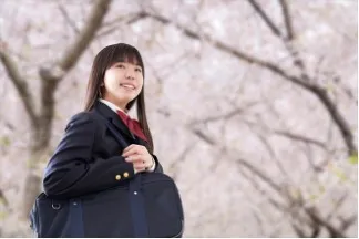 桜を見上げる笑顔の女子高生