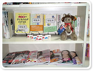 本棚には数多くのコミック本や雑誌、趣味の本等がぎっしり。それらの中にトミカのミニカーがかわいらしく置かれており、何だかホッとする。